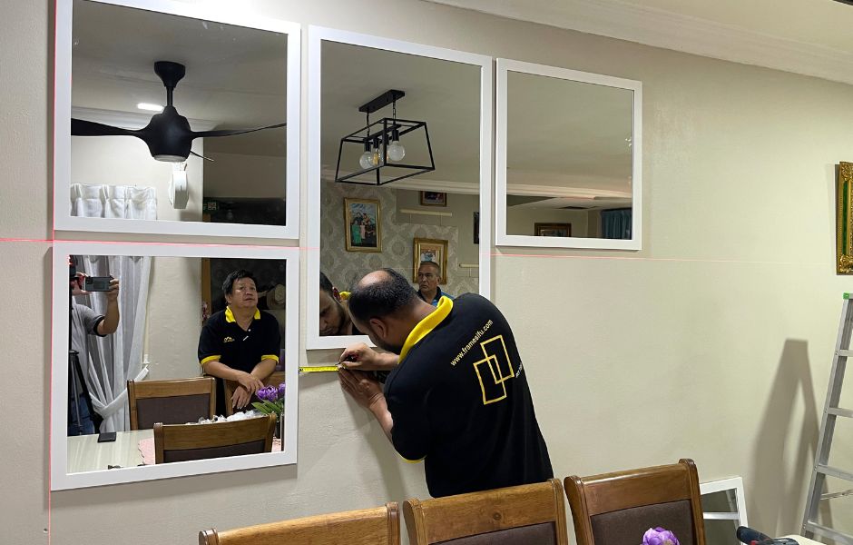 Professional picture frame installation service near a home mirror wall in Malaysia